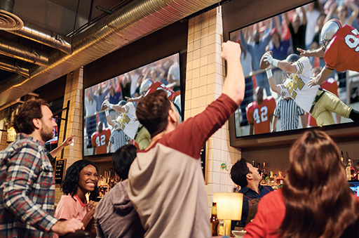 People watching football on big TVs at a restaurant