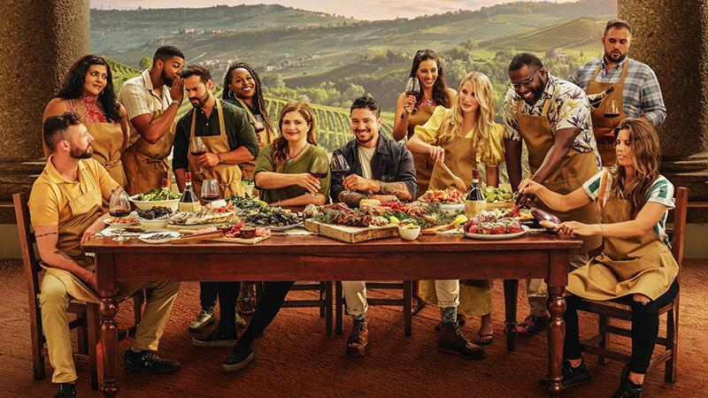 'Ciao House' Cast gathering around a large table of food.