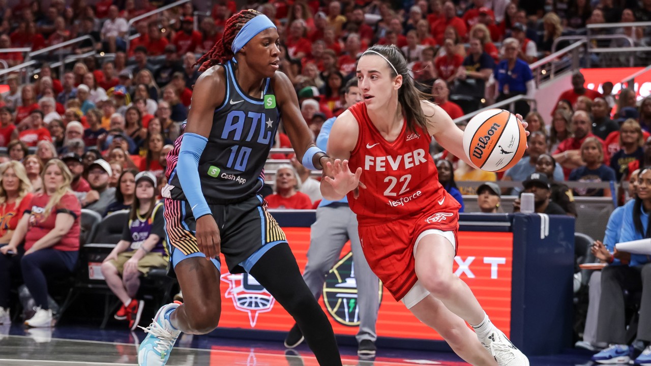 An image of Caitlin Clark driving on a defender from the Atlanta Dream.