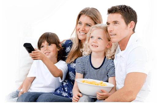 Man and woman sit together with 2 kids holding popcorn and pointing a remote at a TV