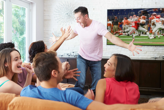 Group of friends excitedly watching football